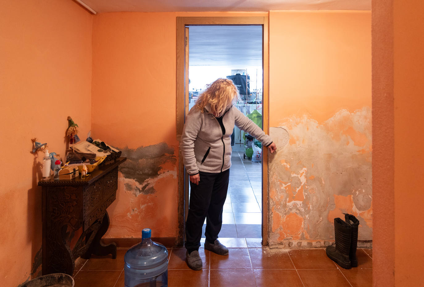 Elena muestra los daños en su casa un mes y medio después de la inundación.