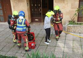 Bomberos desalojando el edificio en el que se ha originado el incendio