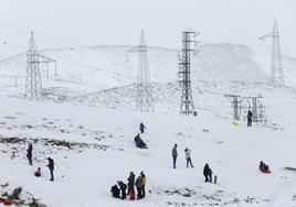 Varias personas juegan con la nieve en el puerto de Pajares.