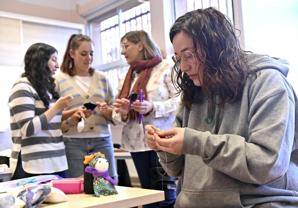 Luisa, Esther, Raquel y Elia, en el taller de costura de El Puente-Salud Mental, con una muñeca Micaela.