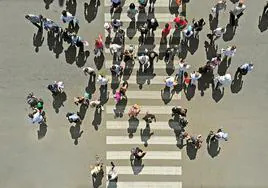 Varias personas atraviesan un paso de peatones.