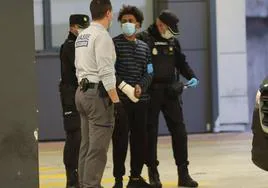 S.H. en el momento de su detención, custodiado por agentes de la Policía Nacional.