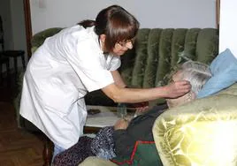 Una mujer presta asistencia a domicilio a una persona mayor en una imagen de archivo.