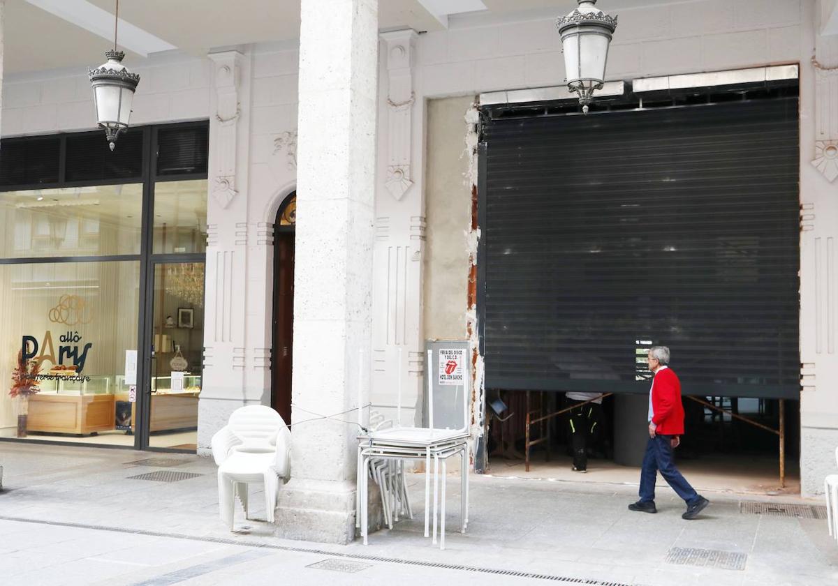 Un hombre camina junto a la verja del nuevo restaurante, al lado de la pastelería francesa.