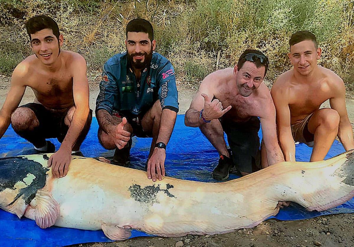 Enrique Sanz Merlo (izquierda) junto a su hermano y sus amigos tras capturar al siluro albino.