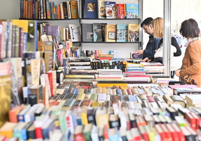 Lectores en busca de libros en un puesto.