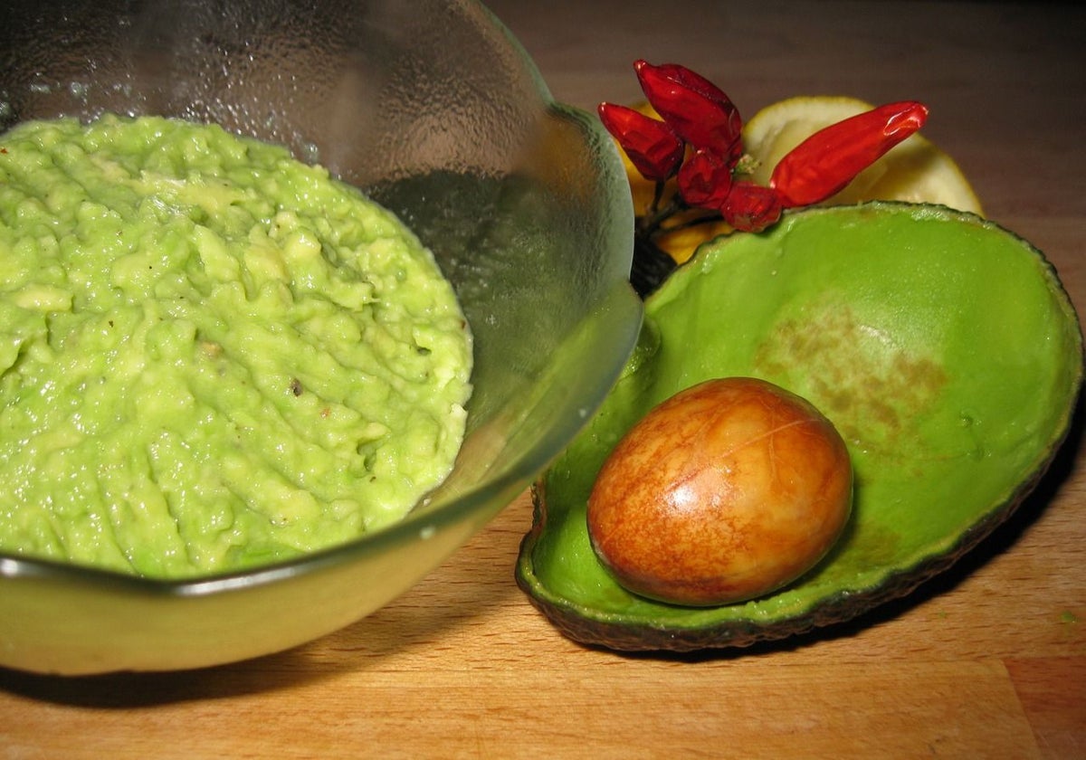 Guacamole casero junto a la cáscara del ingrediente principal.