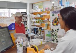 Una farmacéutica atiende a un cliente en Aguilar de Campoo.