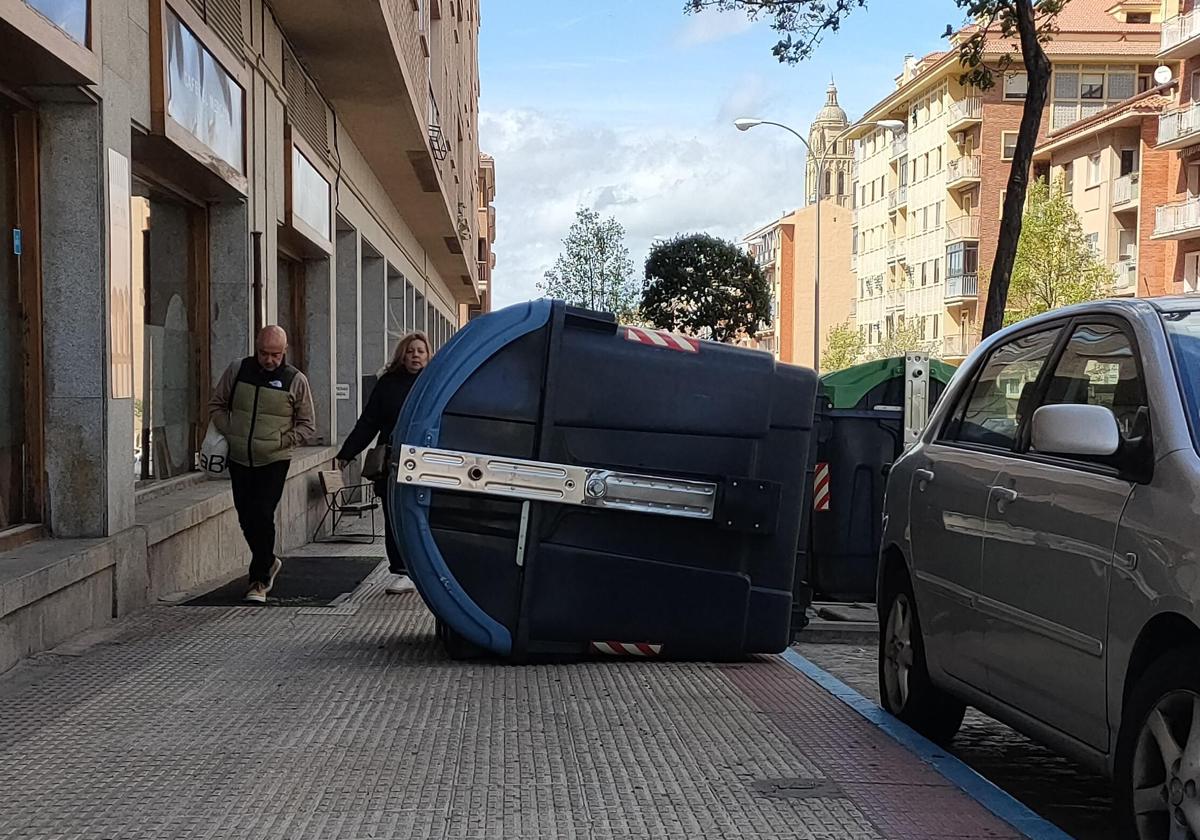 Contenedor de basura volcado por el viento sobre una acera de Ezequiel González.