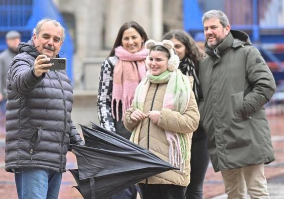 Turistas disfrutando de un Viernes Santo pasado por agua en la Plaza Mayor de Valladolid.