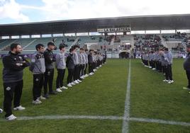 Jugadores y otras personas vinculadas al club conforman un pasillo para recibir a la familia.