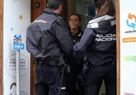 Agentes de la Policía Nacional de Segovia hablan con una persona en una tienda.