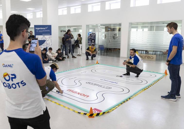 La carrera de robots velocistas atrae la atención de varios alumnos en el edificio de Induva.