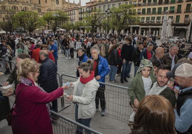 Colas de personas para comprar su ración de ponche segoviano por Autismo Segovia.