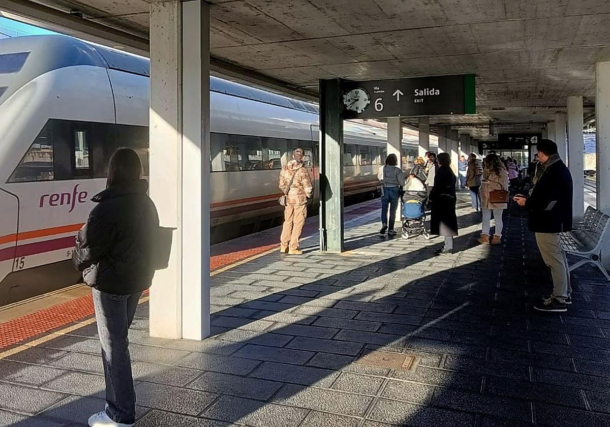 Varios pasajeros esperan la llegada del tren en el andén de la estación Segovia-Guiomar.
