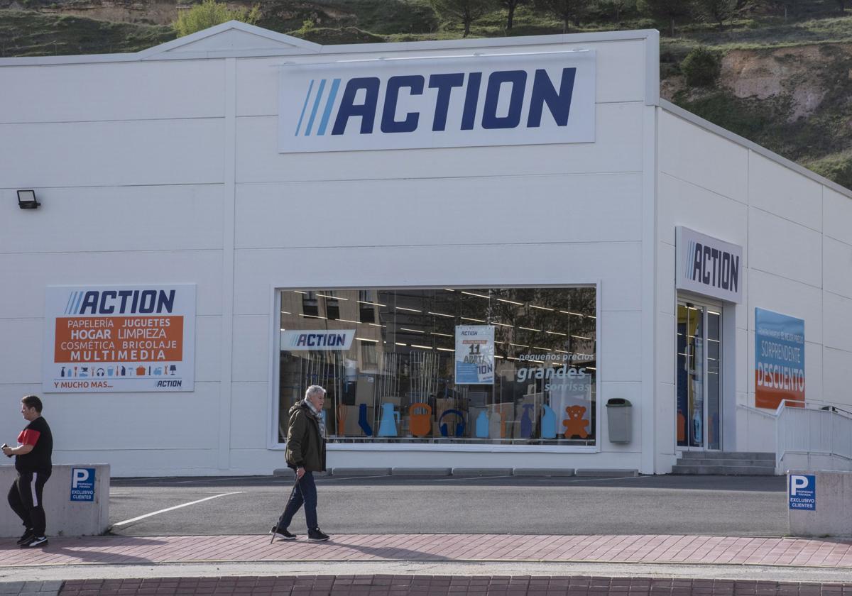 Dos personas pasean frente a la fachada de la tienda Action en el municipio segoviano de La Lastrilla.