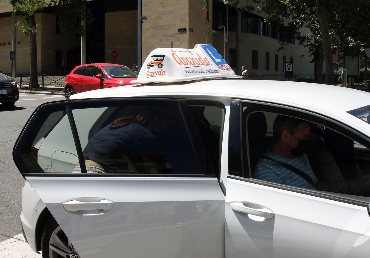 Una alumna sube a un coche de autoescuela en la ciudad de Segovia.