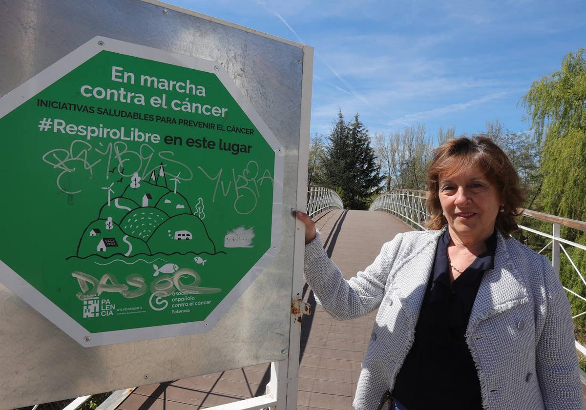 La presidenta de la asociación, junto al cartel de espacio sin humo en Isla Dos Aguas.