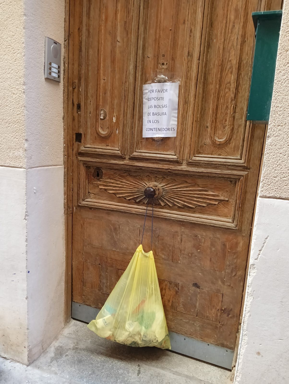 Una bolsa de basura colgada en una puerta del casco histórico.