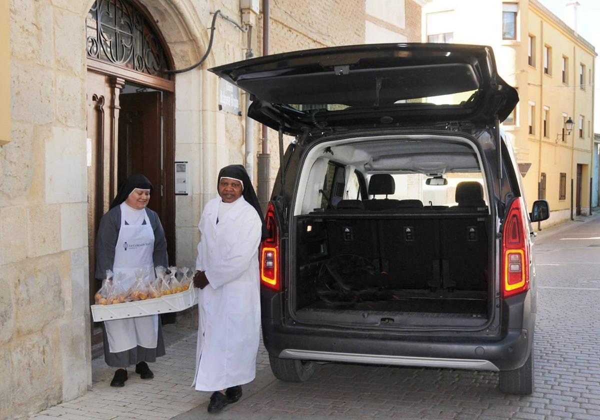 Dos religiosas se disponen a cargar la furgoneta.