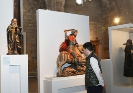 Un hombre contempla una de las imágenes durante la inauguración del nuevo museo-iglesia de Santiago en Carrión de los Condes