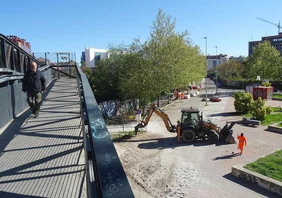 La pasarela hacia La Farola, con la máquina picando la solera aledaña mientras se completa el tramo de acera hasta el paso a nivel.