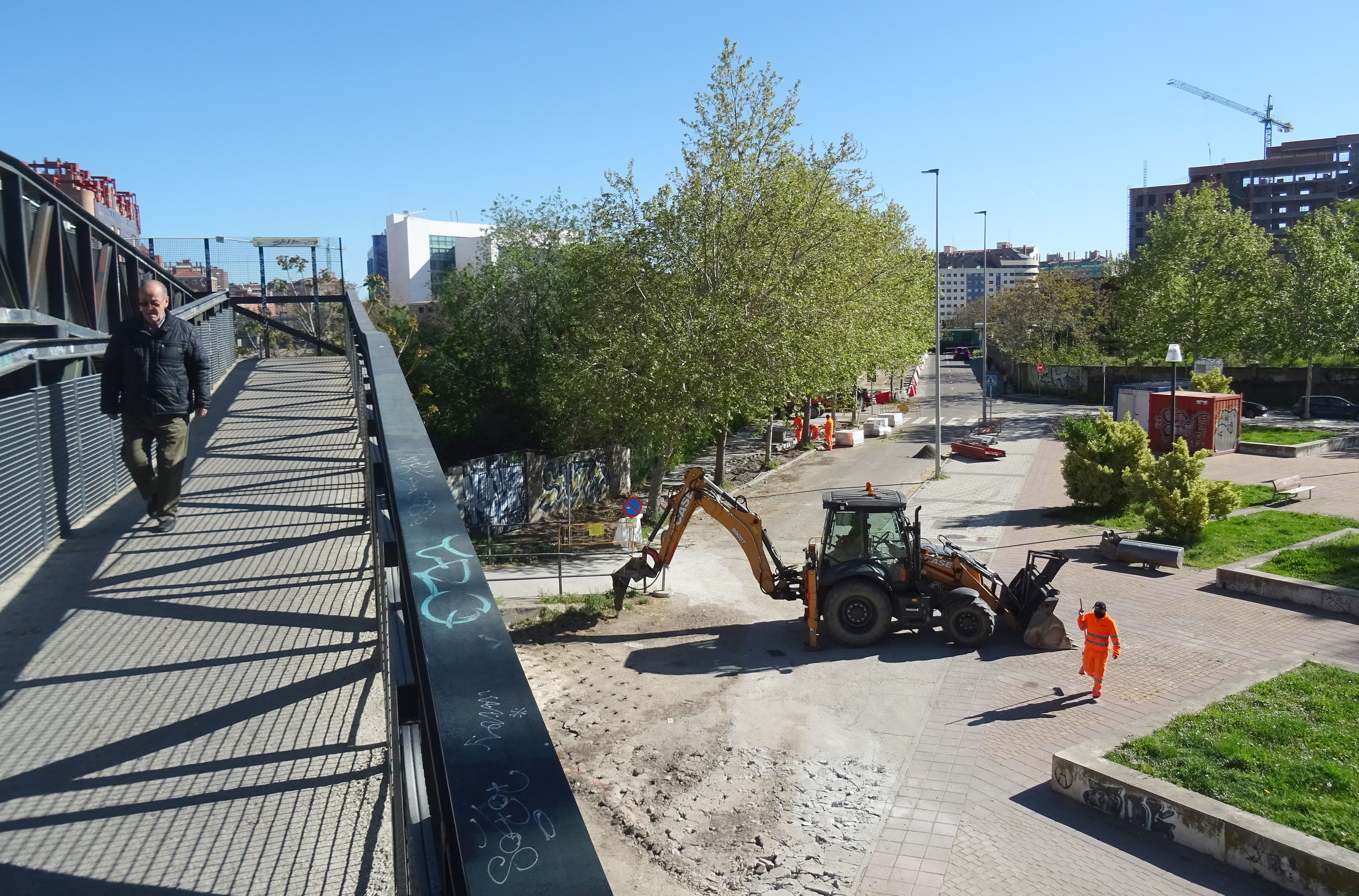 La pasarela hacia La Farola, con la máquina picando la solera aledaña mientras se completa el tramo de acera hasta el paso a nivel.