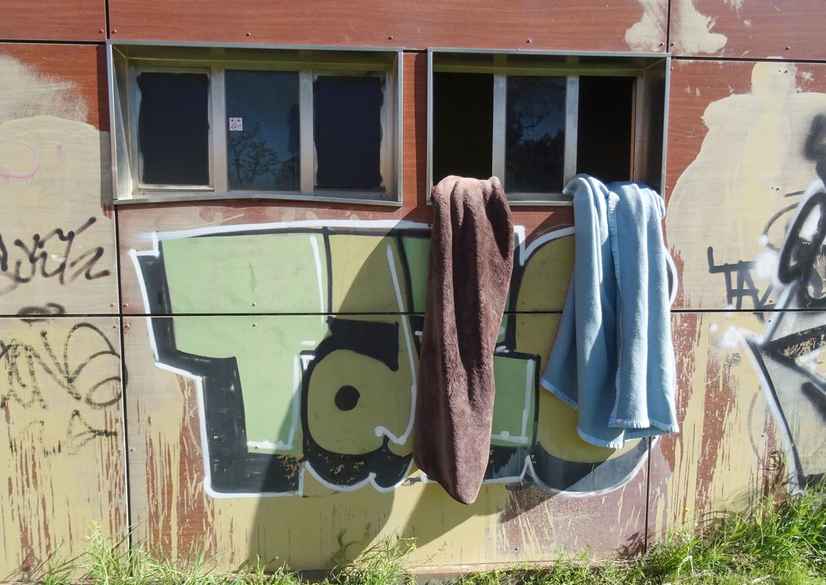 Imagen secundaria 1 - Arriba, precinto policial en torno al antiguo bar del parque de Las Norias. Debajo, a la izquierda, las mantas ventilando en el extetrior de uno de los cuartos ocupados (derecha) del edificio municipal.