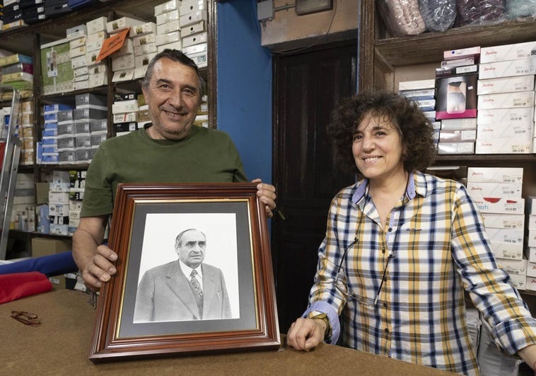 Carlos Campos y María Rosa Sigüenza, con una foto del fundador de la tienda de Tordesillas, Alejando Sigüenza.