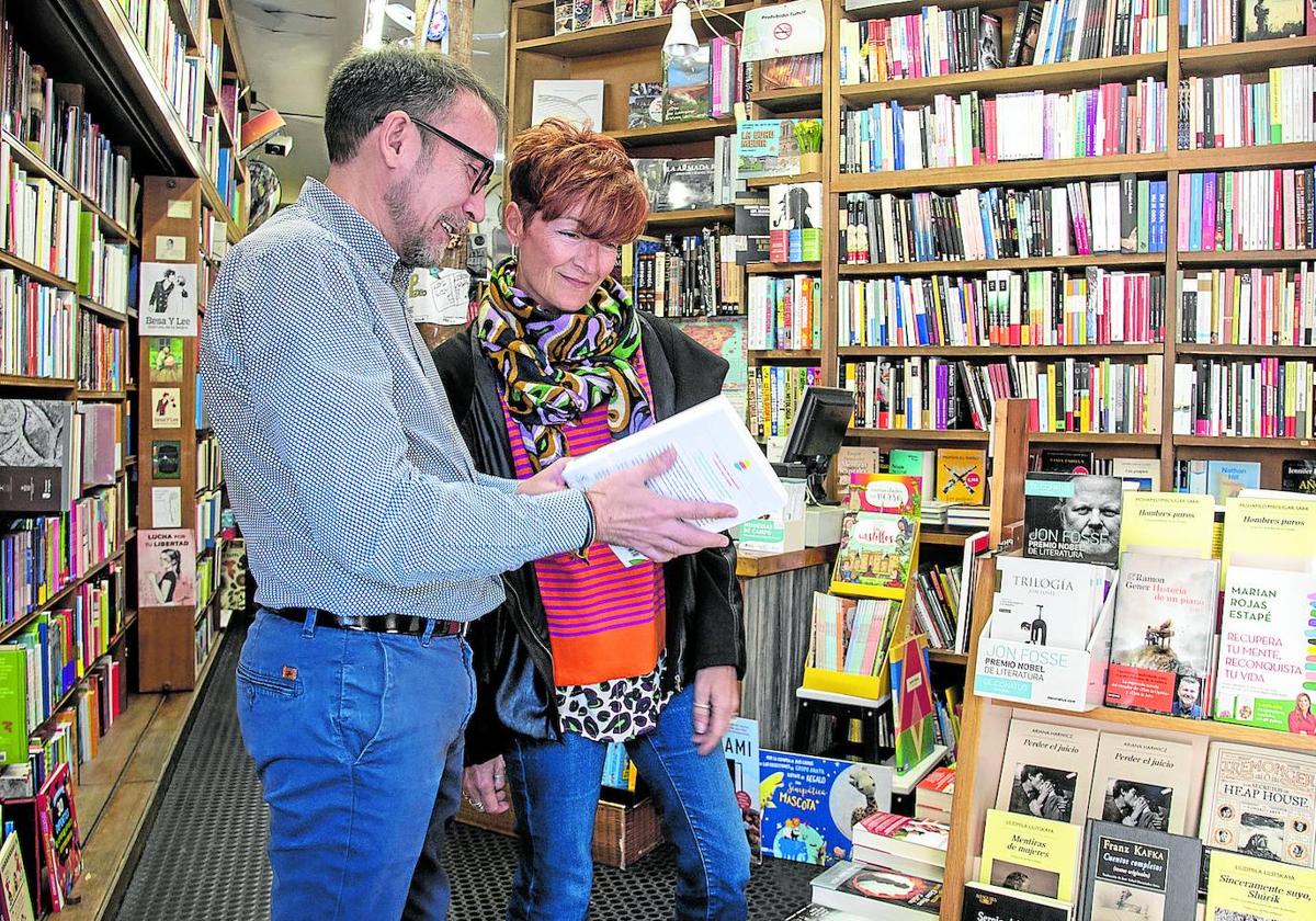 Un librero aconseja a una lectora en una librería de la capital.