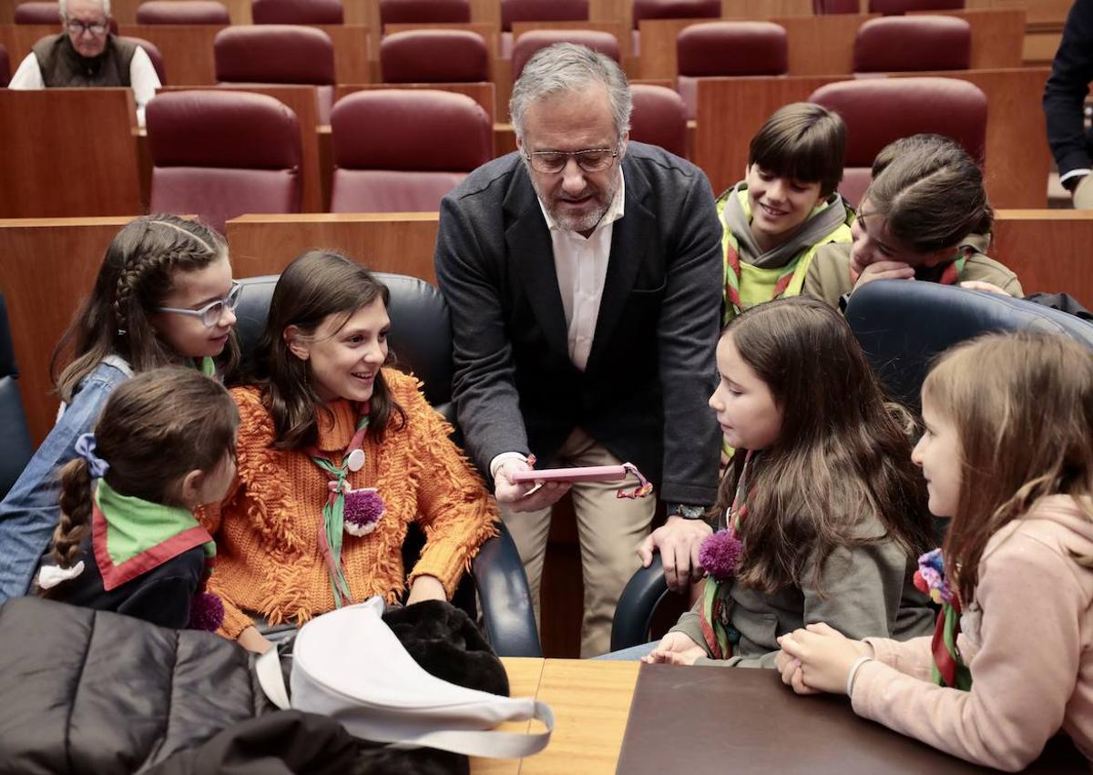 Imagen secundaria 1 - Ambiente en la zona anexa de las Cortes mientras, en el hemiciclo, unos niños cantan una canción al presidente de la Cámara, Carlos Pollán, y otras familias aprovechan para hacerse fotos en el estrado.