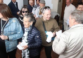 Reparto de pan y quesillo en la romería de San Macos, este jueves.