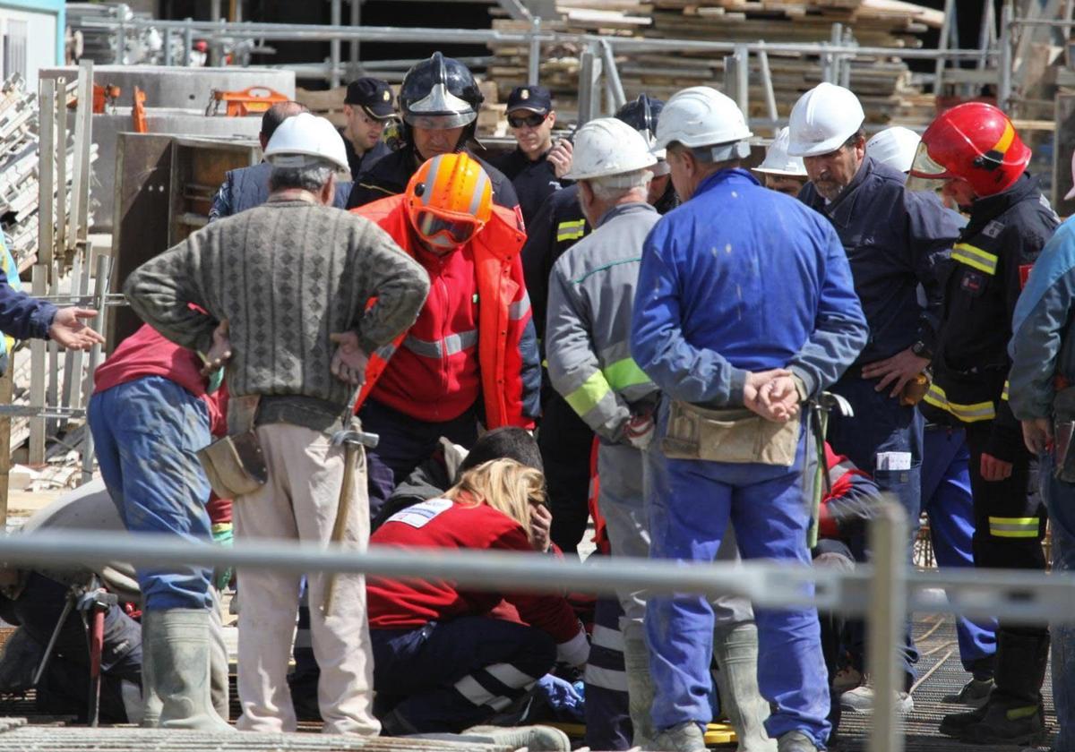 Foto de archivo de personal de Emergencias Sanitarias, bomberos y policías atendiendo a una persona accidentada en una construcción.