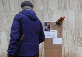 Un hombre observa el cartel y pequeño altar dedicado a Alexandre en la plaza de España.