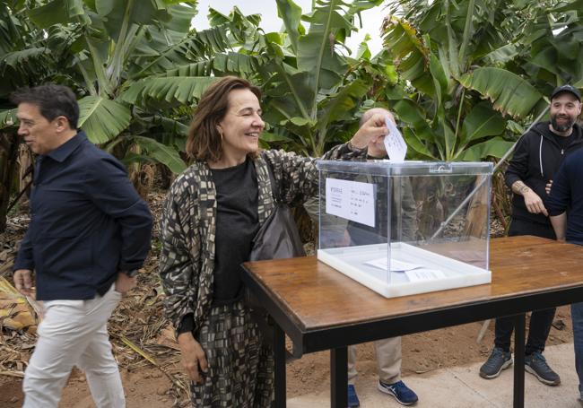 Una cocinera introduce su papeleta en la urna durante la votación.