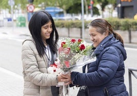 Una hija hace entrega de un ramo de rosas a su madre