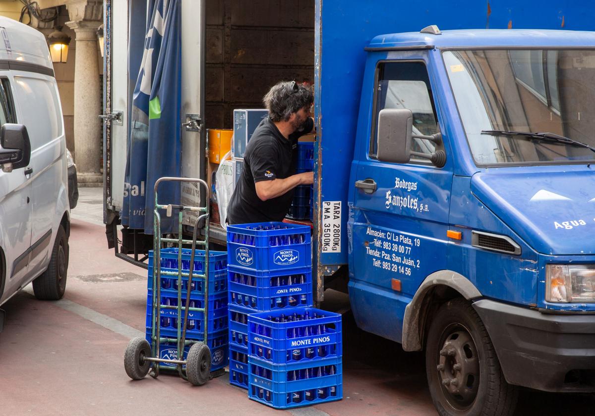 Un repartidor suministra agua mineral a establecimientos hosteleros del centro de Valladolid.