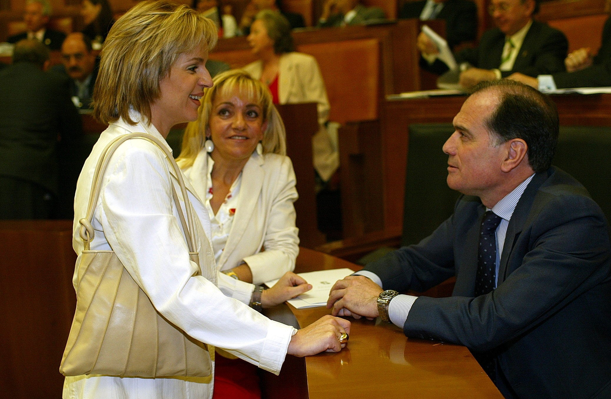 Julio 2003. Silvia Clemente conversa con Tomás Villanueva ante la mirada de Isabel Carrasco durante el pleno de investidura de Juan Vicente Herrera.