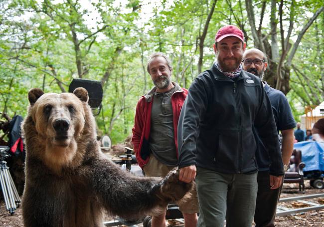 Tom Fernández con Tima, el oso protagonista de '¿Para qué sirve un oso?' en un descanso del rodaje. Tras él, los actores Gonzalo de Castro y Javier Cámara.