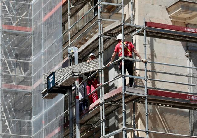 Dos operarios este miércoles, durante el montaje de la estructura desde la que se restaurará el edificio.