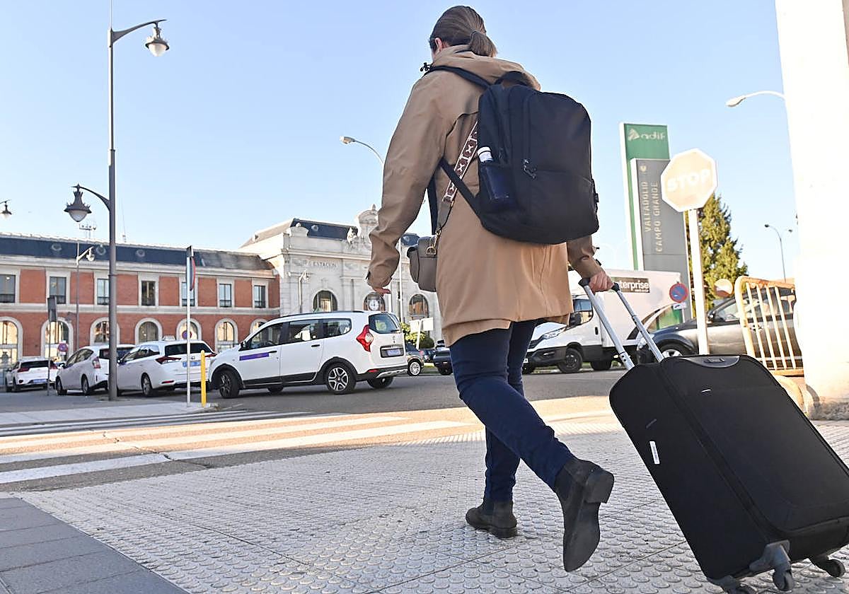 Una joven, maleta en mano, accede al recinto de la estación de trenes de Valladolid.