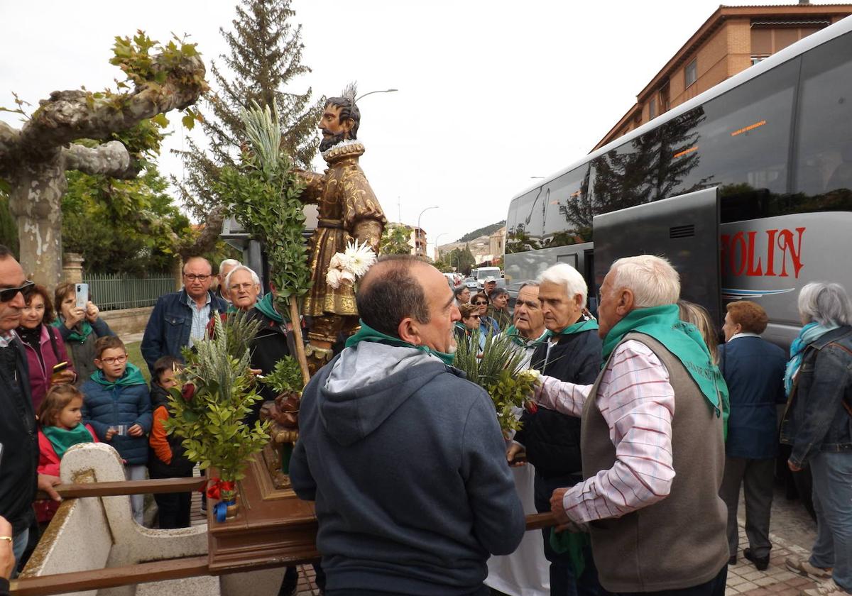 Miembros de la cofradía y de la plataforma se disponen a subir al santo al autobús para trasladarlo a la pradera.