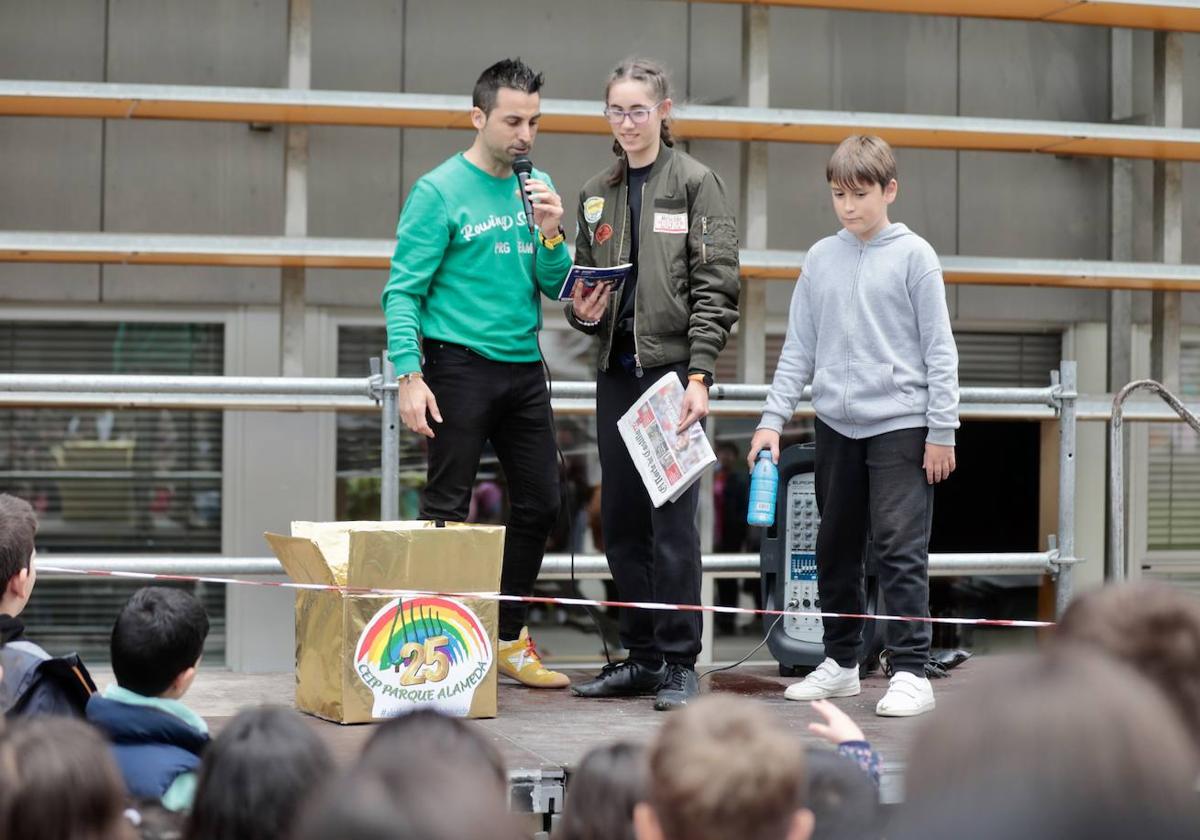 El director del CEIP Parque Alameda y dos alumnos depositando un ejemplar de El Norte