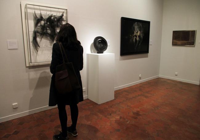 Una mujer observa una de las obras de la exposición.