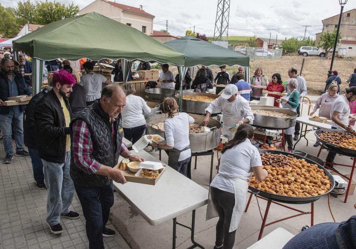 Cola de visitantes para recoger la ración de cocido popular en la Feria del Garbanzo de Valseca, este sábado.