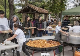 Los cocineros peraparan las raciones de cocido para los comensales que aguardan la cola en la Feria del Garbanzo de Valseca