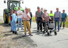 Vecinos de Muñopedro, a la salida del pueblo, en la carretera objeto de las quejas por su deficiente estado.