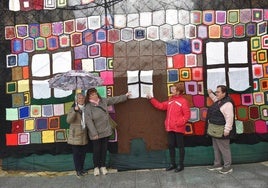 Cuatro de las tejedoras posan junto a la pared de ganchillo hecha por ellas.