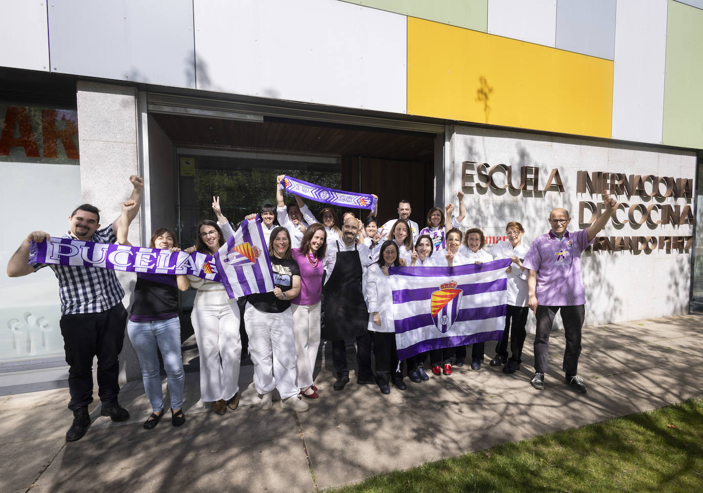 Miembros de la Escuela Internacional de Cocina, con banderas y bufandas.