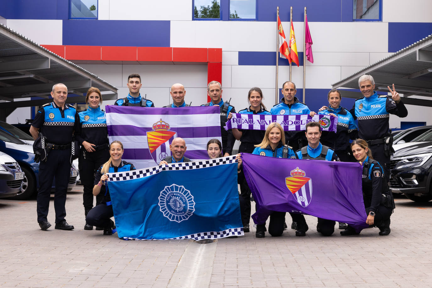 Miembros de la Policía Municipal posan con los colores blanquivioletas en la comisaría de La Victoria.